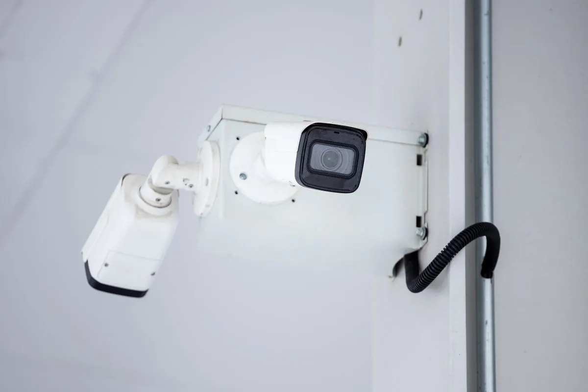 White bullet security camera fixed to a wall