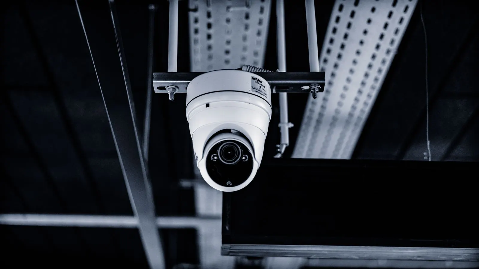Dome security camera mounted under a dark industrial ceiling